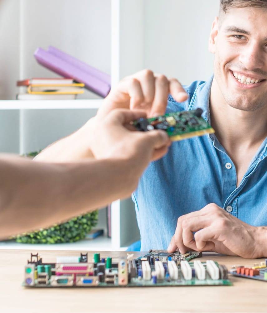 Man smiling and holding a circuit board component